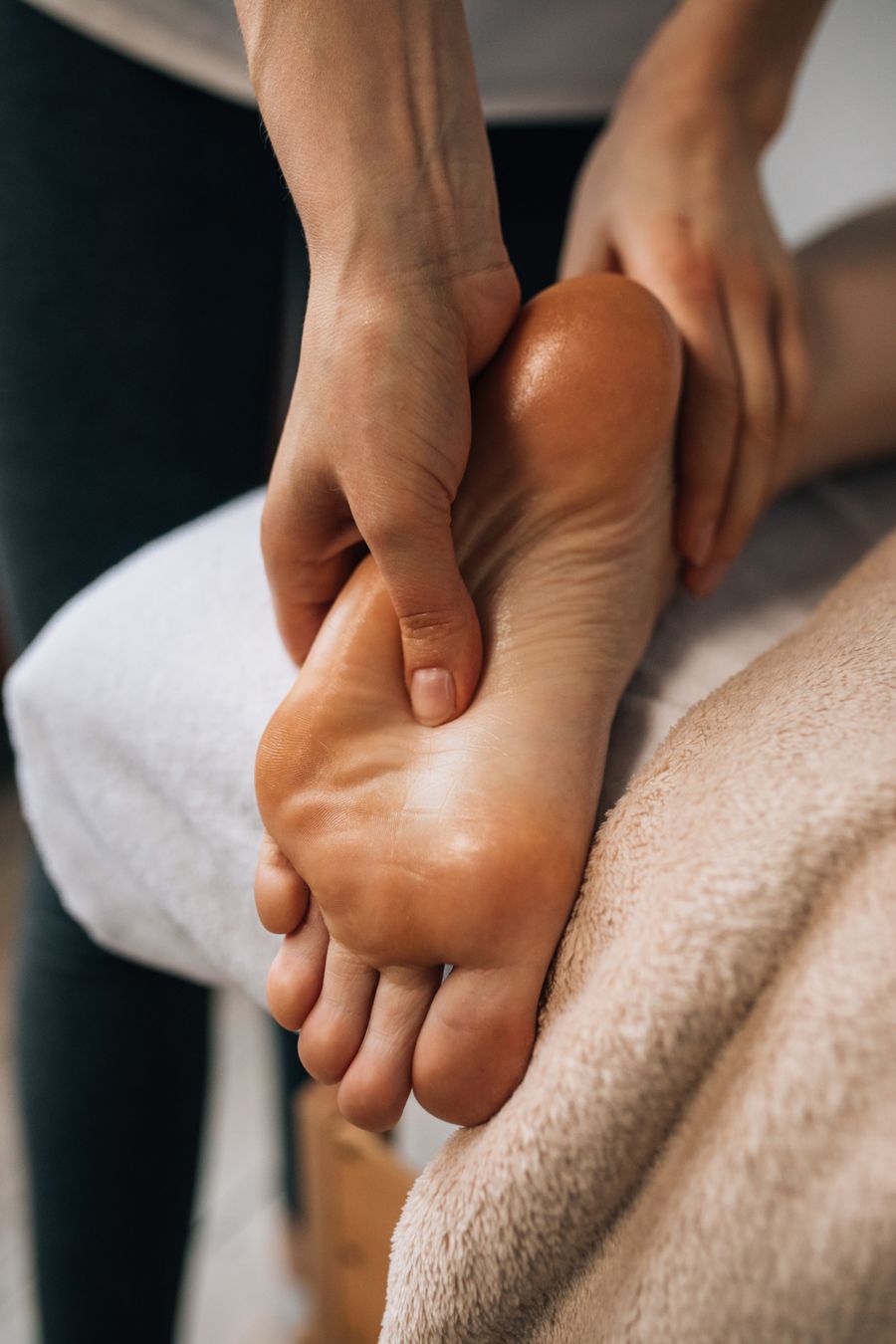 Soin expert du pied, pression précise des pouces sur la voûte plantaire